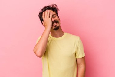 Pembe arka planda izole olmuş genç beyaz bir adam gülüyor, kaygısız, doğal bir duygu..