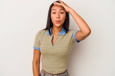 Beyaz arka planda izole edilmiş genç Latin kadın uzaklara bakıyor ve elini alnına koyuyor..