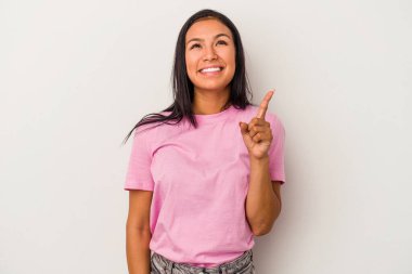 Beyaz arka planda izole edilmiş genç Latin bir kadın iki parmağı da boş bir alan gösteriyor..