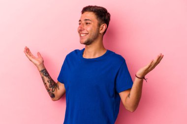 Sarı arka planda izole edilmiş dövmeleri olan, neşeli gülüşlü beyaz bir genç. Mutluluk kavramı.