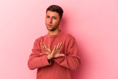 Sarı arka planda dövmeleri olan beyaz bir adam inkar hareketi yapıyor.