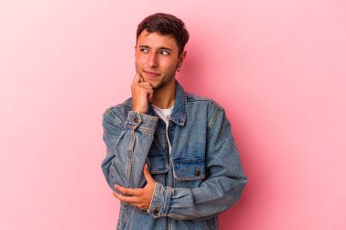 Sarı arka planda izole edilmiş beyaz dövmeli genç bir adam. Bir şeyin fotokopi odasına baktığını düşünerek rahatlamış..