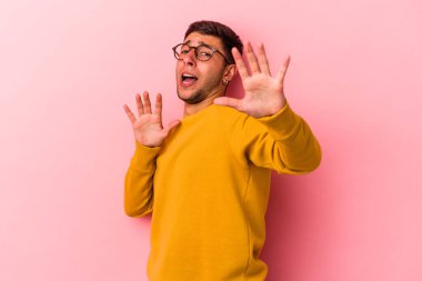 Sarı arka planda dövmeleri olan beyaz bir genç yakın bir tehlike nedeniyle şoka uğruyor.