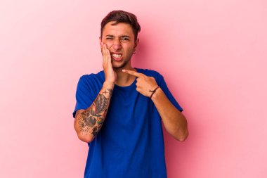 Sarı arka planda izole edilmiş dövmeleri olan beyaz bir genç adam. Güçlü bir diş ağrısı, azıdişi ağrısı var..