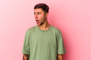 Sarı arka planda dövmeleri olan beyaz bir adam gördüğü bir şey yüzünden şoka uğruyor..