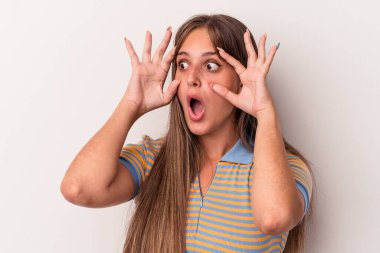 Beyaz arka planda izole genç beyaz kadın bir başarı fırsatı bulmak için gözlerini açık tutuyor..