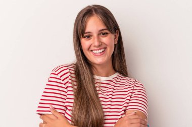 Beyaz arka planda kendini güvende hisseden, kararlılıkla kollarını kavuşturan beyaz tenli genç bir kadın..