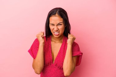 Pembe arka planda izole edilmiş genç Latin kadın gergin ellerle çığlık atıyor..