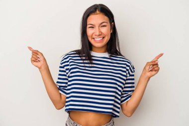 Beyaz arka planda izole edilmiş genç Latin bir kadın farklı kopya alanlarını gösteriyor, birini seçiyor, parmaklarıyla gösteriyor.