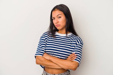 Beyaz arka planda izole edilmiş genç Latin bir kadın şüpheli, belirsiz, seni muayene ediyor..