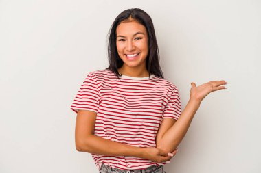 Beyaz arka planda izole edilmiş genç Latin bir kadın bir avuç içinde fotokopi alanı ve belinde bir el daha olduğunu gösteriyor..