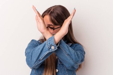 Beyaz arka planda izole genç beyaz kadın iki kolu çapraz tutuyor, inkar kavramı.