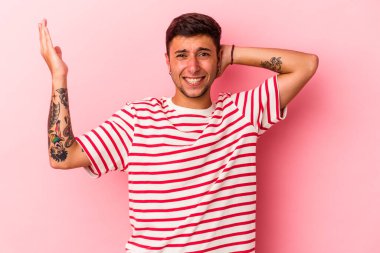 Sarı arka planda izole edilmiş dövmeleri olan genç beyaz bir adam öfkeyle bağırıyor..