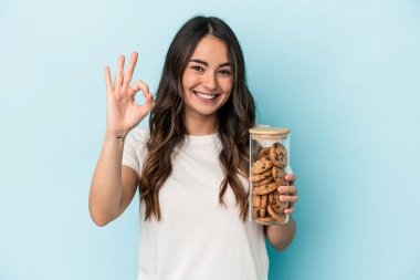 Beyaz bir kadın, sarı arka planda izole edilmiş, neşeli ve kendinden emin bir şekilde hareket ediyor..