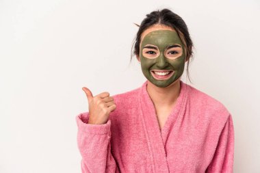 Young caucasian woman wearing a facial mask isolated on white background smiling and raising thumb up