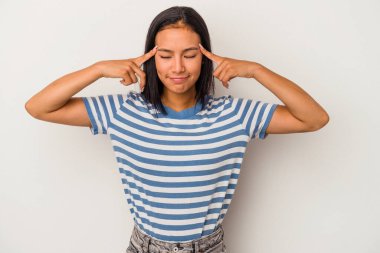 Beyaz arka planda izole edilmiş genç Latin bir kadın bir göreve odaklanmış, işaret parmaklarını işaret ediyor..