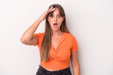 Beyaz arka planda izole genç beyaz kadın yüksek sesle bağırıyor, gözleri açık ve elleri gergin tutuyor..