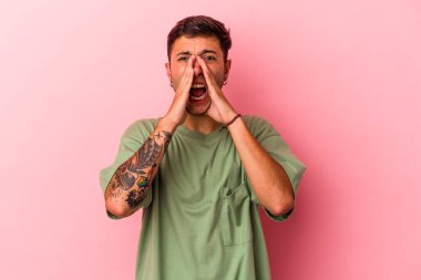 Sarı arka planda izole edilmiş dövmeleri olan beyaz bir genç öne doğru heyecanlı bağırıyor..