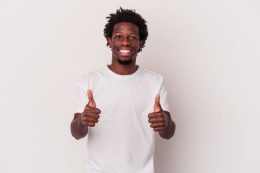 Genç Afrikalı Amerikalı adam beyaz arka planda izole edilmiş gülümsüyor ve başparmağını kaldırıyor.