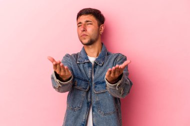 Sarı arka planda izole edilmiş, dudakları kıvrılmış ve hava öpücüğü yollamak için avuç içi tutan beyaz bir adam..