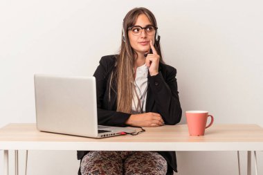 Beyaz arka planda yalnız başına seyahat eden beyaz tenli genç bir kadın şüpheli ve şüpheci bir ifadeyle yana bakıyor..