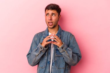 Sarı arka planda dövmeleri olan genç beyaz bir adam. Kafasında bir plan kuruyor..