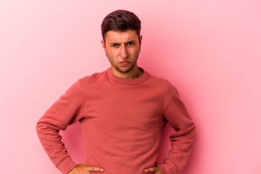 Sarı arka planda izole edilmiş beyaz dövmeli genç bir adam üzgün, ciddi yüzlü, mutsuz ve hoşnutsuz..