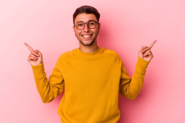 Sarı arka planda, farklı kopya alanlarını gösteren dövmeleri olan genç beyaz bir adam. Birini seçiyor, parmaklarıyla gösteriyor..