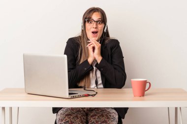 Beyaz arka planda yalnız başına seyahat eden beyaz tenli genç bir kadın şans için dua ediyor, hayrete düşmüş ve ağzı açık..