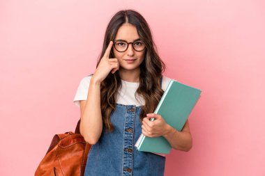 Young caucasian student woman isolated on pink background pointing temple with finger, thinking, focused on a task.