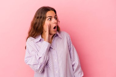 Pembe arka planda izole edilmiş beyaz bir kadın gördüğü bir şey yüzünden şoka uğruyor..