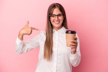 Pembe arka plandaki izole edilmiş, kendini beğenmiş, gururlu ve kendinden emin genç beyaz bir kadın gömleğin fotokopi odasını işaret ediyor.