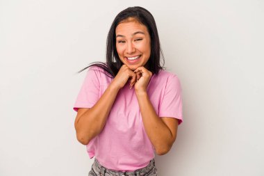 Beyaz arka planda izole edilmiş genç Latin bir kadın şans için dua ediyor, şaşırmış ve ağzını açıp önüne bakıyor..