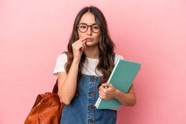 Young caucasian student woman isolated on pink background with fingers on lips keeping a secret.