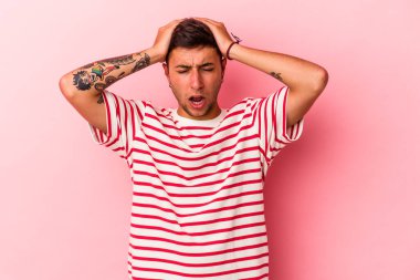 Sarı arka planda izole edilmiş dövmeleri olan genç beyaz adam şaşırdı ve şok oldu..