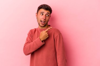 Sarı arka planda izole edilmiş dövmeleri olan beyaz bir genç gülümsüyor ve keyifli görünüyor..