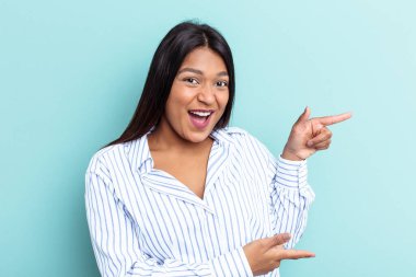 Genç Venezuelalı bir kadın mavi arka planda izole edilmiş..