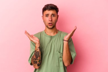 Sarı arka planda izole edilmiş dövmeleri olan genç beyaz adam şaşırdı ve şok oldu..