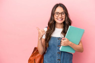 Young caucasian student woman isolated on pink background smiling and raising thumb up