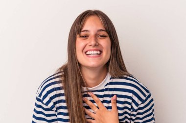 Beyaz arka planda izole genç beyaz kadın yüksek sesle gülüyor elini göğsüne koyuyor..