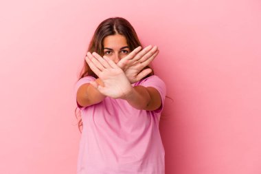 Pembe arka planda izole edilmiş beyaz bir kadın inkar jesti yapıyor.