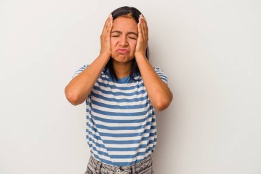 Beyaz arka planda yalnız kalmış, ağlayan ve sızlanan genç Latin bir kadın..