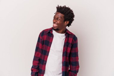 Beyaz arka planda izole edilmiş genç bir Afrikalı Amerikalı. Rahatlamış ve mutlu bir şekilde gülüyor. Dişlerini göstererek boynunu geriyor..