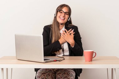 Beyaz arka planda izole bir şekilde seyahat eden beyaz tenli genç bir kadın, dostane bir ifadeye sahip, avuçlarını göğsüne bastırıyor. Aşk konsepti.