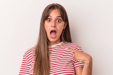 Beyaz arka planda izole edilmiş genç beyaz bir kadın parmağını göstererek şaşırdı, geniş bir gülümsemeyle..