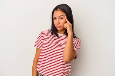 Beyaz arka planda izole edilmiş genç Latin bir kadın parmağıyla tapınağı işaret ediyor, düşünüyor ve bir göreve odaklanıyor..