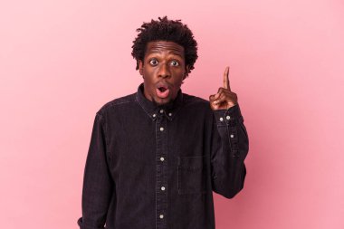 Genç Afrikalı Amerikalı bir adam pembe arka planda izole edilmiş. Harika bir fikri var, yaratıcılık kavramı..