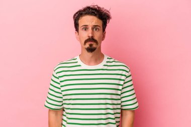 Pembe arka planda soyutlanmış beyaz bir adam üzgün, ciddi bir yüz, mutsuz ve hoşnutsuz..