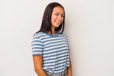 Beyaz arka planda izole edilmiş genç Latin kadın ellerini kalçasında tutuyor..