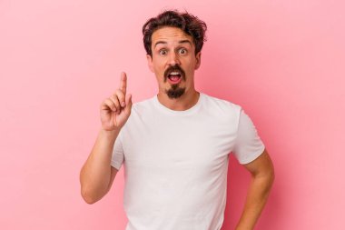Pembe arka planda soyutlanmış genç beyaz bir adamın bir fikri var, ilham verici bir kavram..